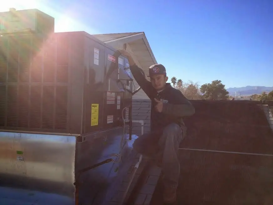 HVAC technician performing AC Tune-Up on a rooftop unit in Stayton